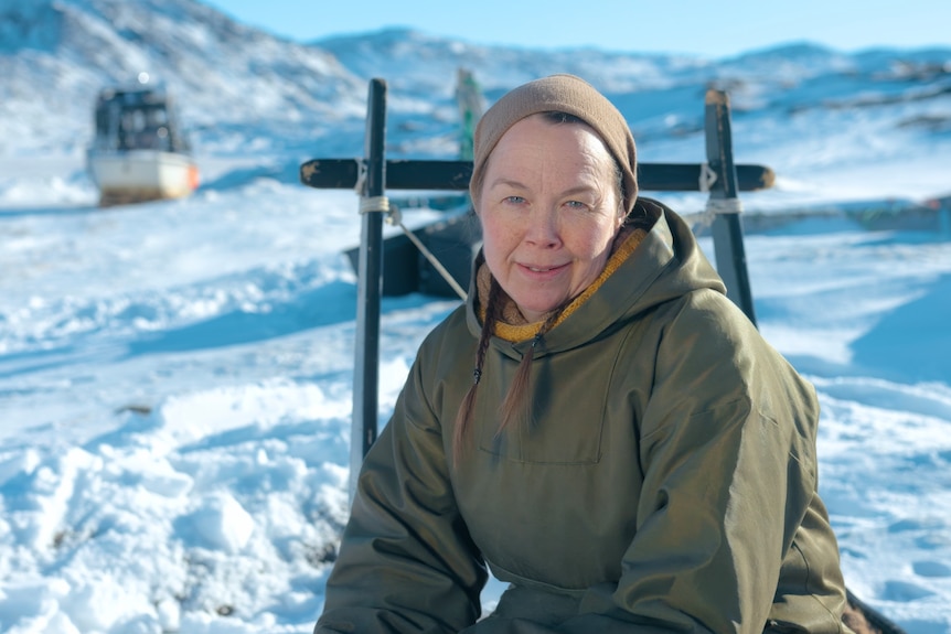 A woman sits in a snowy landscape