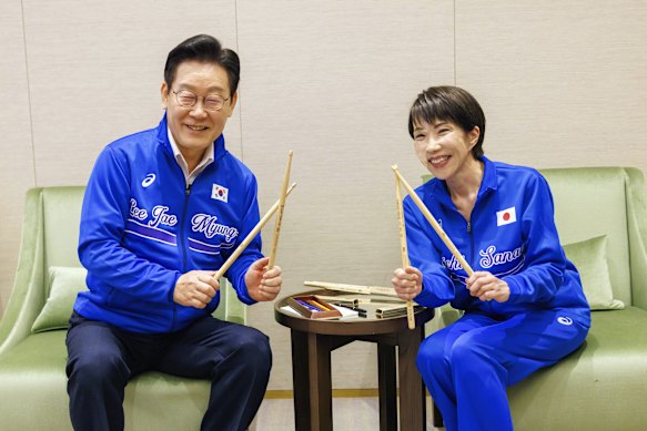 Japanese Prime Minister Sanae Takaichi (right) and South Korean President Lee Jae Myung (left) pose for a photo at their music session.