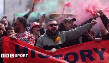 Manchester United fans protest with banners and flares