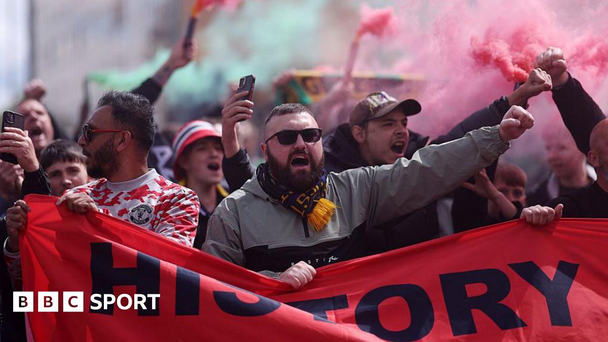 Manchester United fans protest with banners and flares