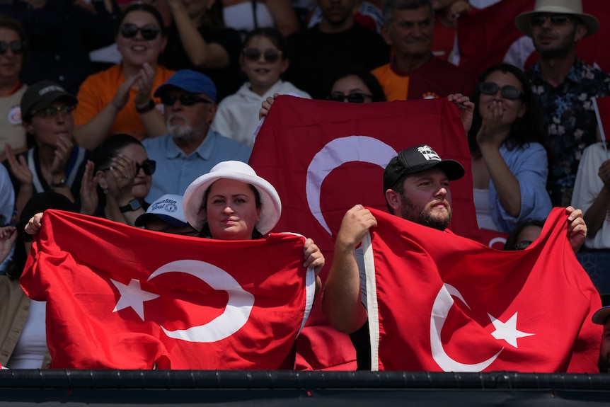 Supporters of Zeynep Sonmez fly the Turkish flag at the Australian Open.