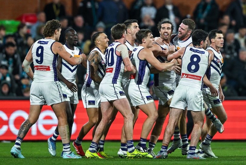 Alex Pearce is mobbed by teammates after his match-winning goal against Port Adelaide./