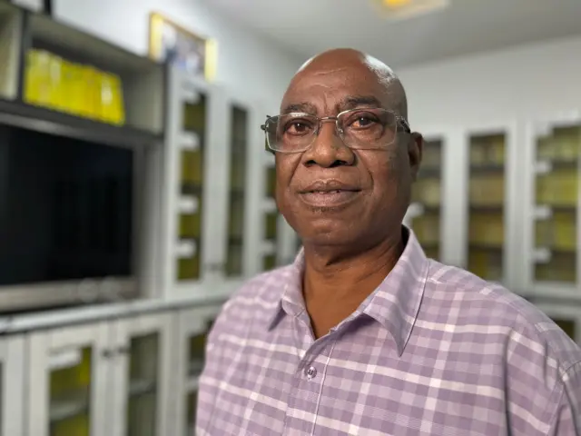 Ledum Mitee in a striped shirt and glasses. E dey look into di camera. 