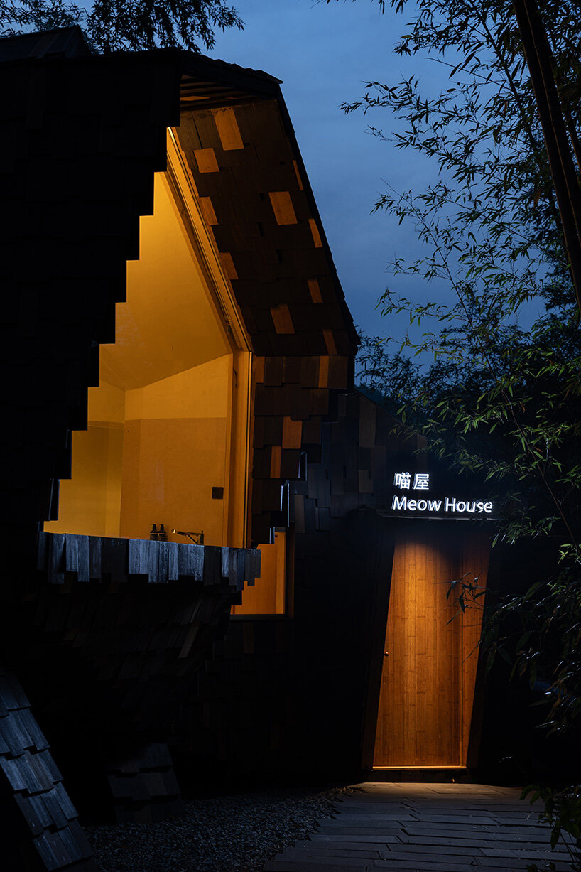patchwork exterior of 'cat house' in china's anji forest is clad in discarded bamboo tiles