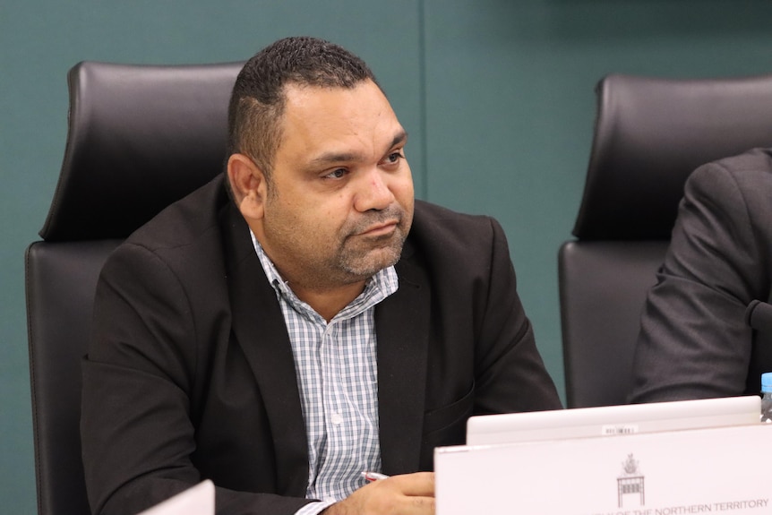 an aboriginal man wearing a suit in parliament