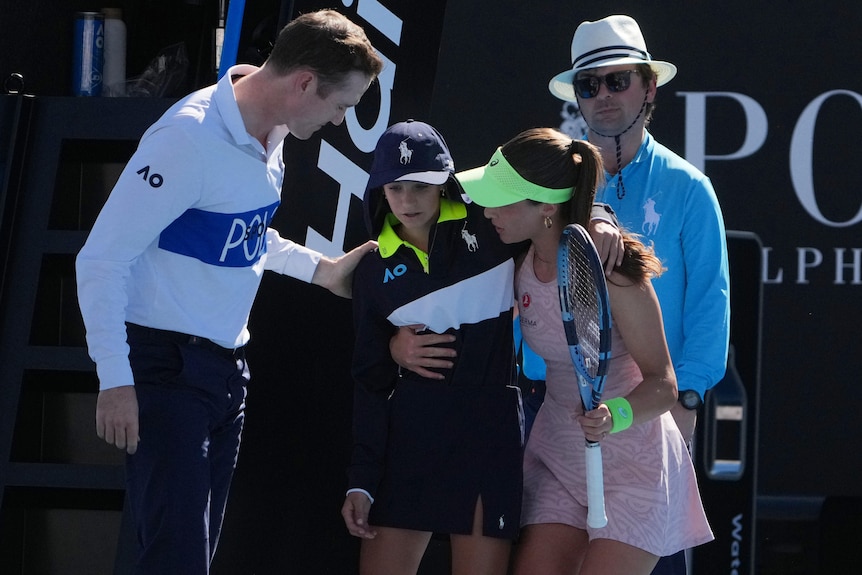 Zeynep Sonmez and a chair umpire help a ball kid at the Austraian Open.