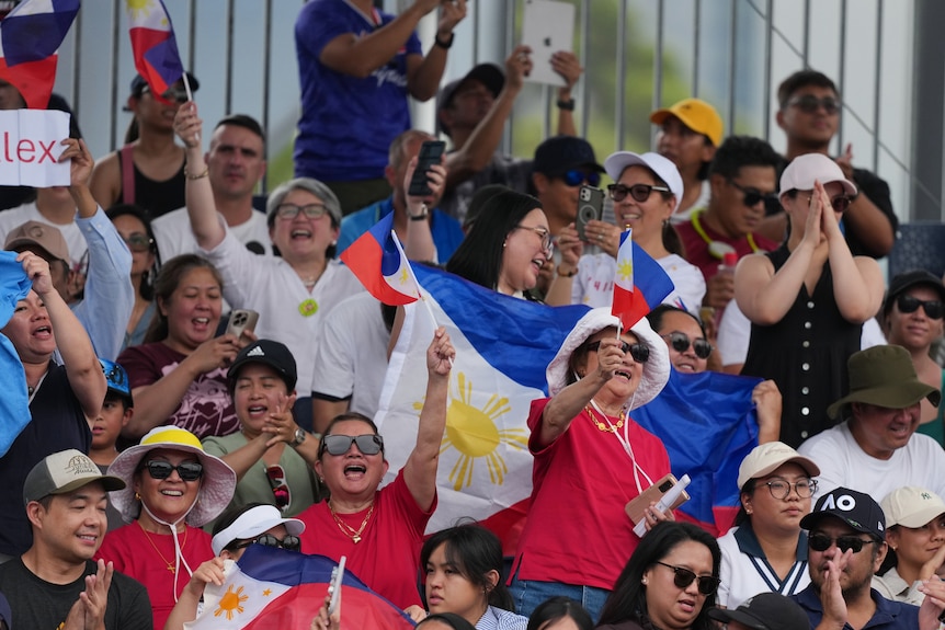 Fans with Philippines flags cheer for Alex Eala at the Australian Open.