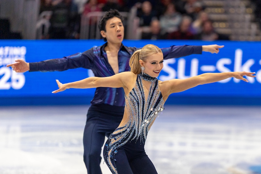 Holly Harris and Jason Chan skate with their arms outstretched