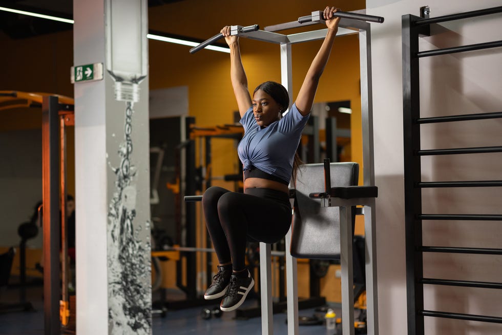 beautiful black woman working out on fitness exercise equipment at gym