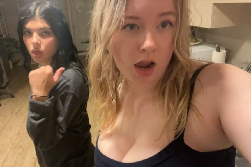 Two girls are making funny facial expressions while taking a photo.