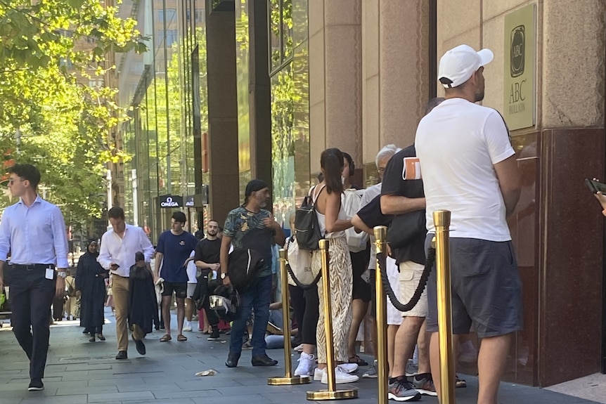 People lined up inside ropes outside ABC Bullion.