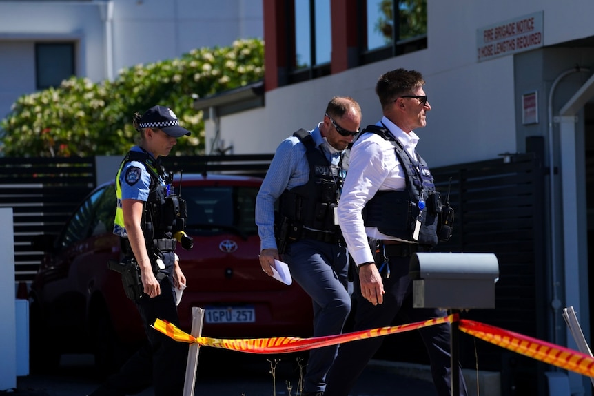 Police walk towards a house in Bentley. 