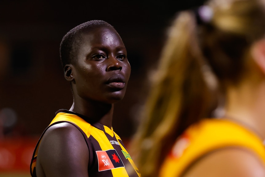 A close up of former AFLW player Akec Makur Chuot during a game. She has a solemn look on her face.