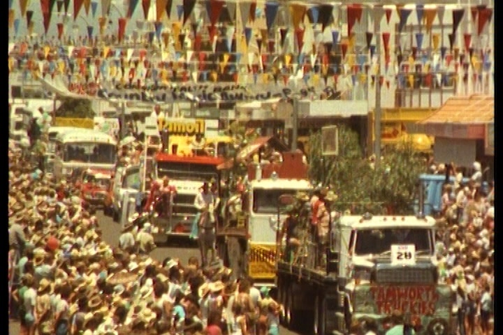 People lining the street watching a country music parade