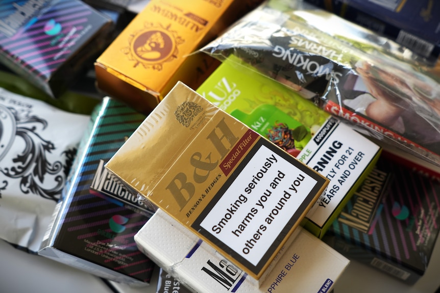 Packets of illegal cigarettes displayed on a table.