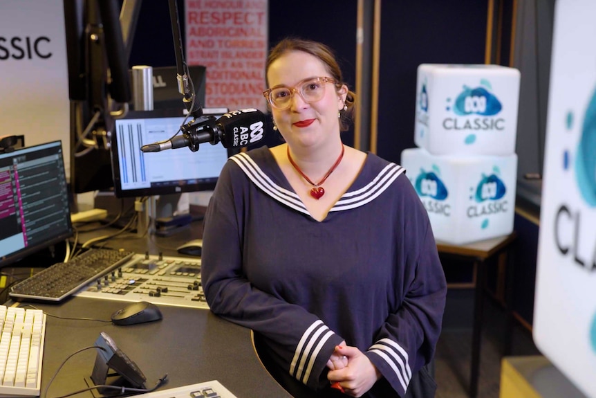 Vanessa Hughes stands in the ABC Classic studio surrounded by white ABC Classic light boxes