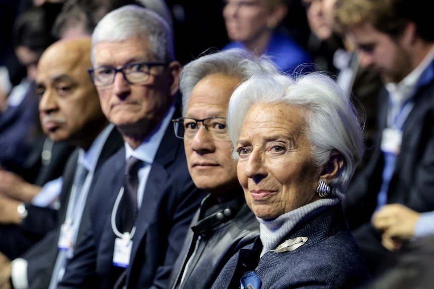 Christine Lagarde sits at the World Economic Forum looking over her shoulder.