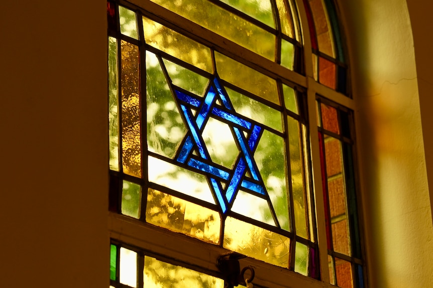 A stain window glass with a star of david emblem on it.