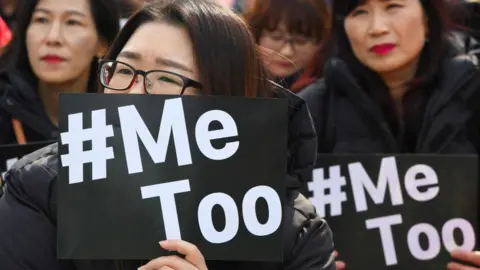 AFP via Getty Images Two Korean women hold signs that read "#MeToo"