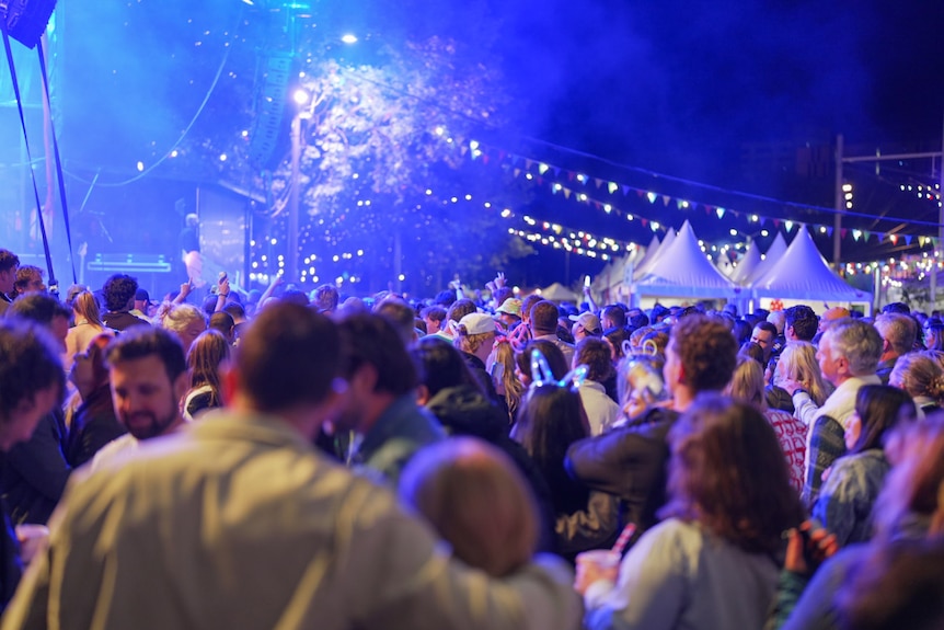 People gathering at a big colourful music and food festival.