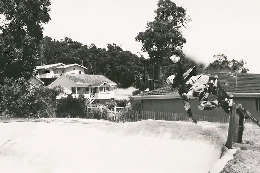 A skateboarder using a fence post for a trick. 