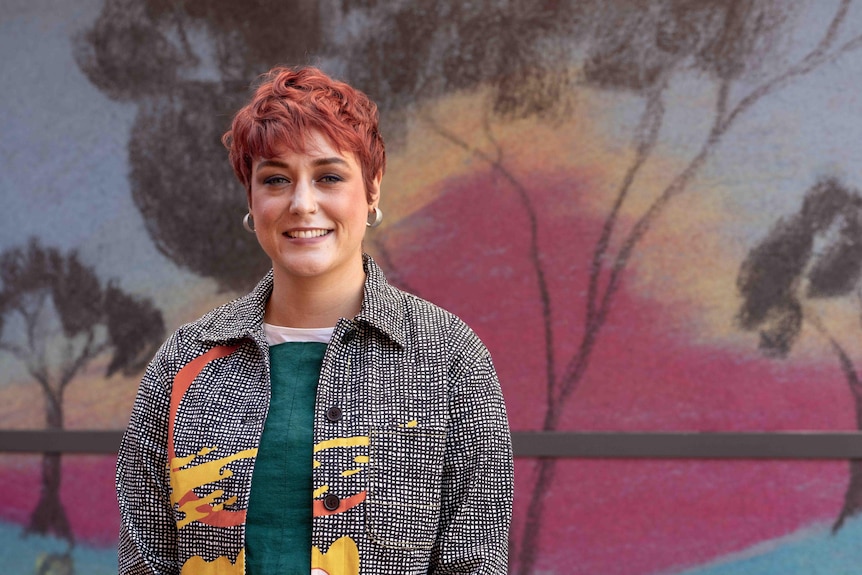 A medium shot of woman in front of a mural