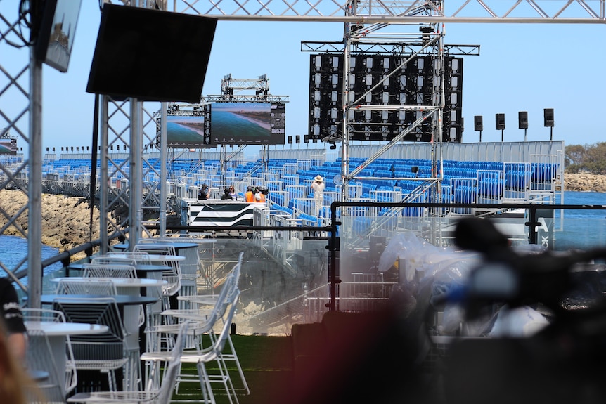 Blue grandstands line the water