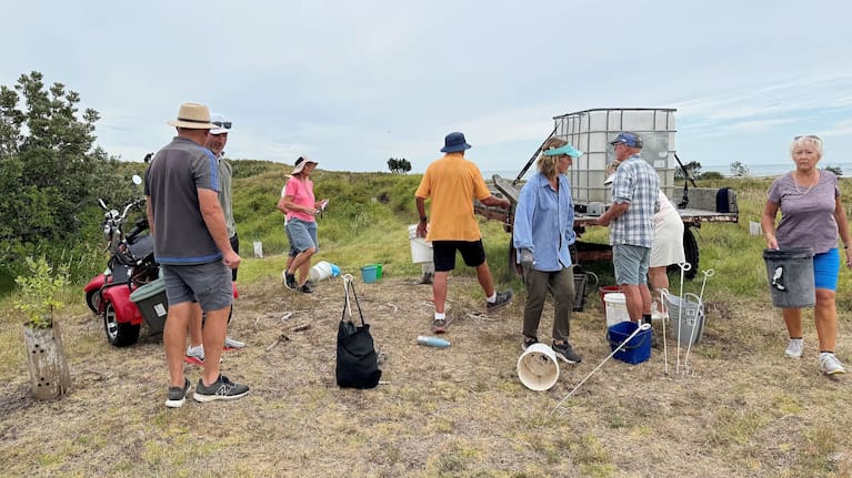 Club members take part in a watering day, carrying buckets of water to each of the new trees planted throughout the dunes.