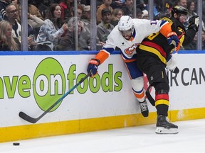 Marcus Pettersson, right, checks New York Islanders' Anthony Duclair during the second period