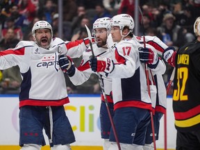 Alex Ovechkin (8), Tom Wilson (43) and Dylan Strome (17) celebrate Strome's goal against the Canucks during the first period