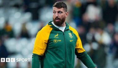 Jean Kleyn wearing South Africa training leisure kit, walking on the pitch while looking over his right shoulder before a match for the country