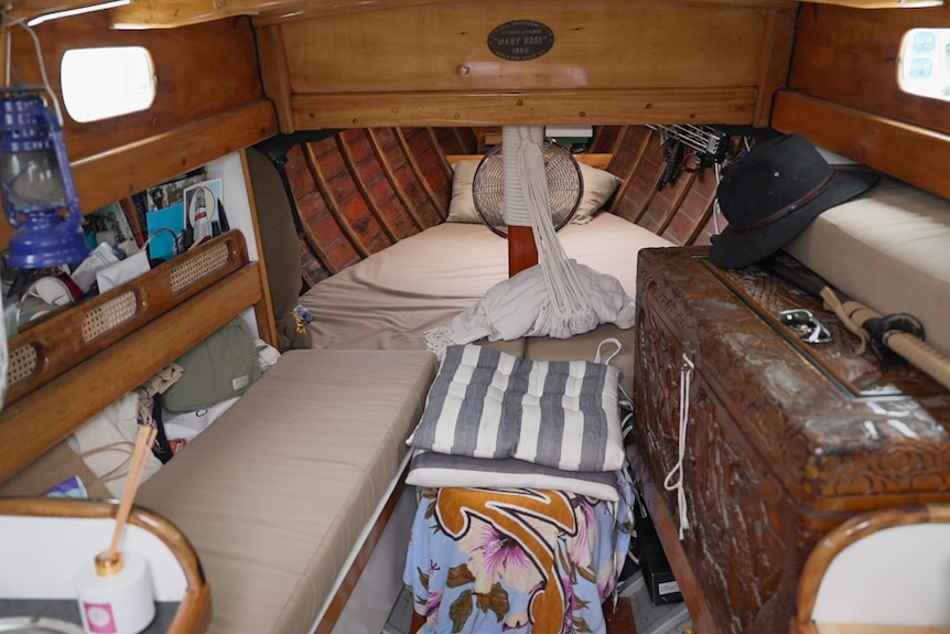 Photograph of the interior of a small yacht, including bed and storage spaces