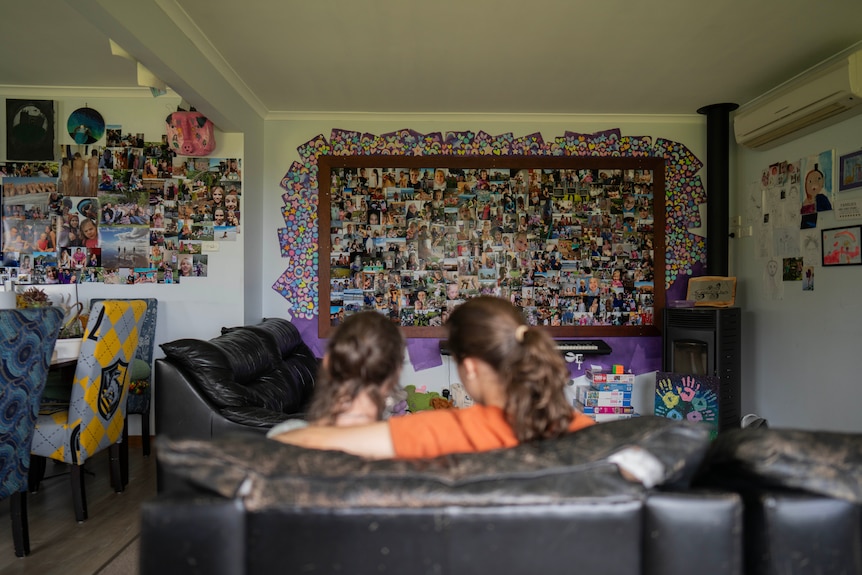 A mother sitting in her living room with her daughter on the couch.