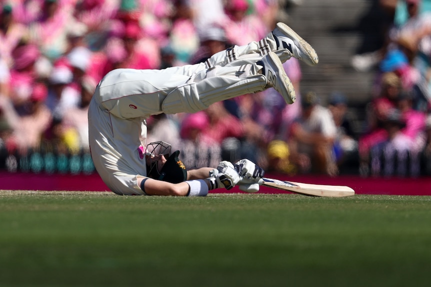 Australia batter Steve Smith rolls onto his back at the SCG.