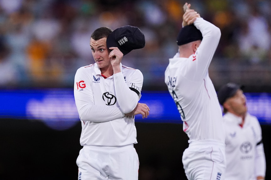 England fielder Harry Brook holds his cap to his head and pulls a face during the second Ashes Test at the Gabba.
