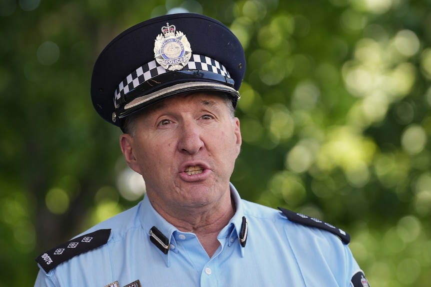 A senior police officer speaks at a press conference outdoors.