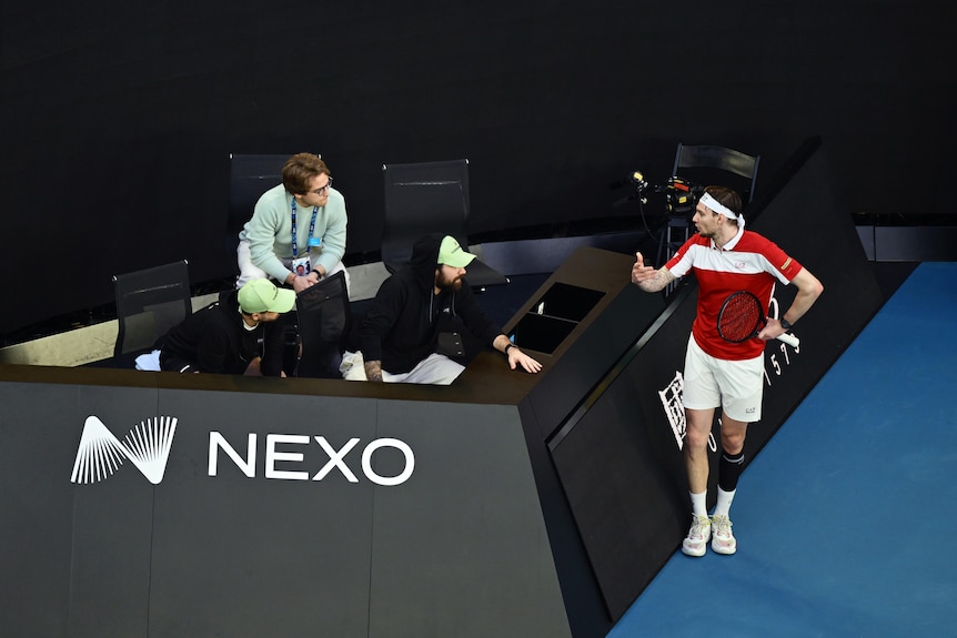 Alexander Bublik speaks angrily to his coaches on the side of the court