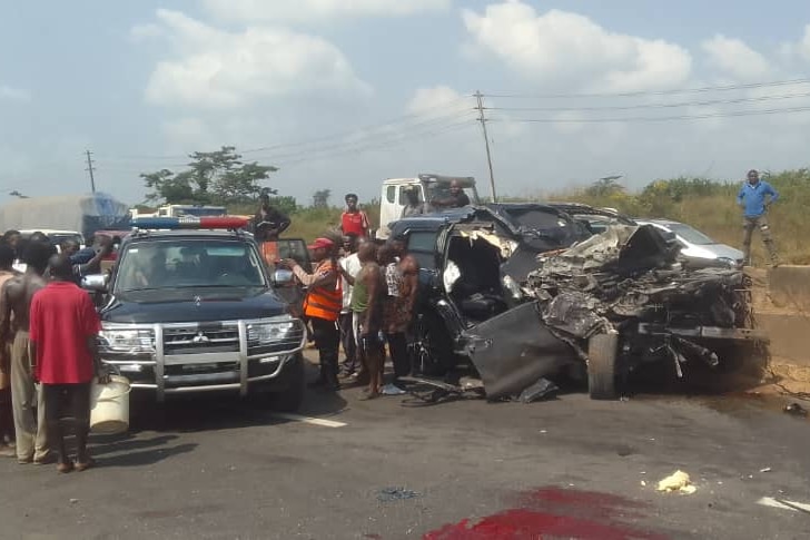 A black SUV's bonnet is crumpled and torn apart on the side of a road