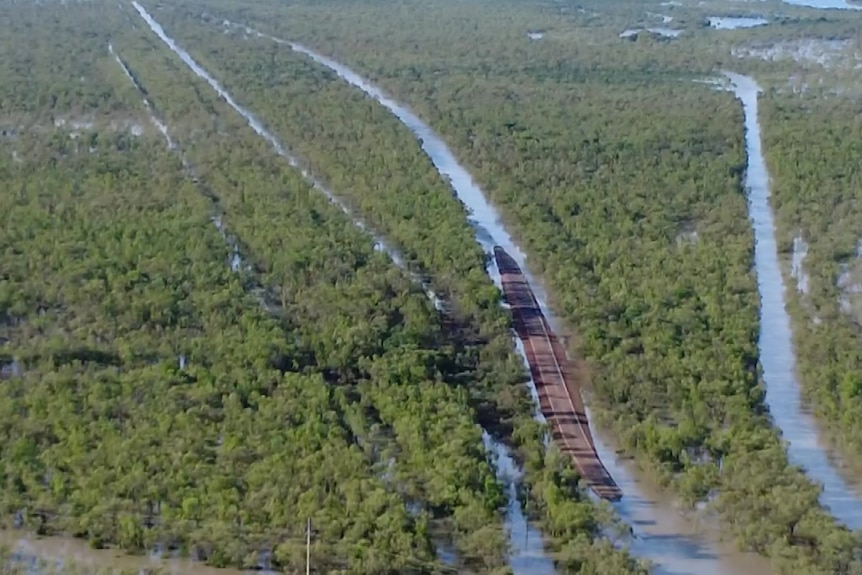 A helicopter shot of a green landscape with flooded rivers and creeks running through it
