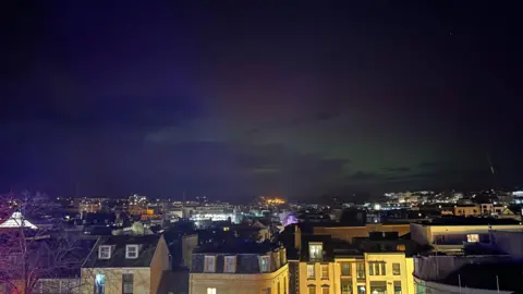 WINTER B/BBC WEATHER WATCHERS A gentle red and green light over the skies of St Helier, the builidings are in the foreground 