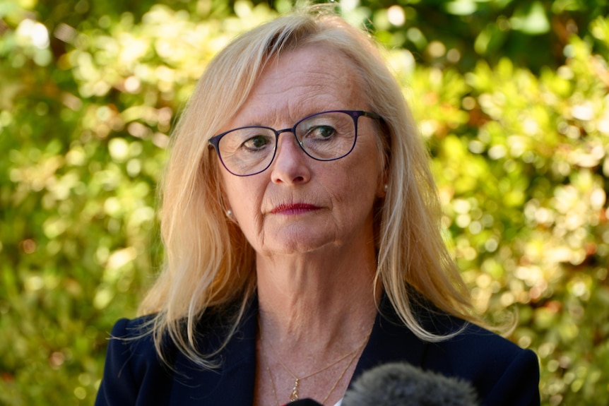 A close-up shot of Shirley who wears black rimmed glasses and her long blonde hair out