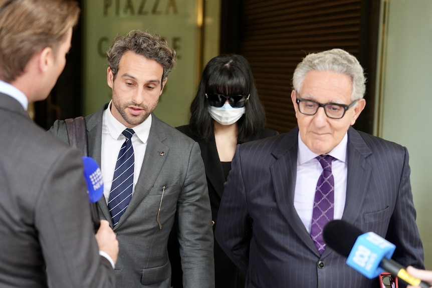 lanlan yang arrives at court wearing sunglasses and face mask