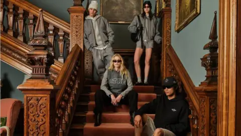 The Couture Club Four models are wearing some of the autumn/winter collection from The Couture Club as they pose on a large, ornate wooden staircase. 