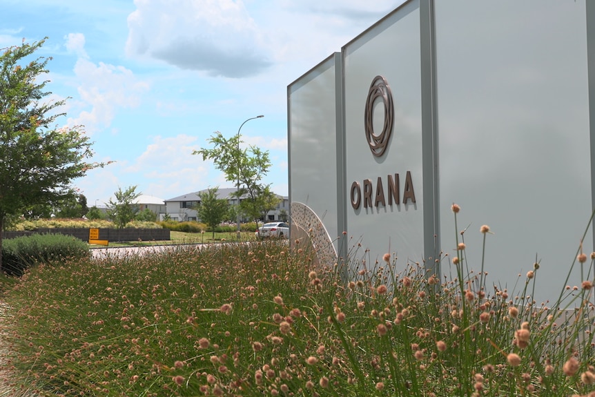 An entry sign into an estate that reads Orana and plants in front of it