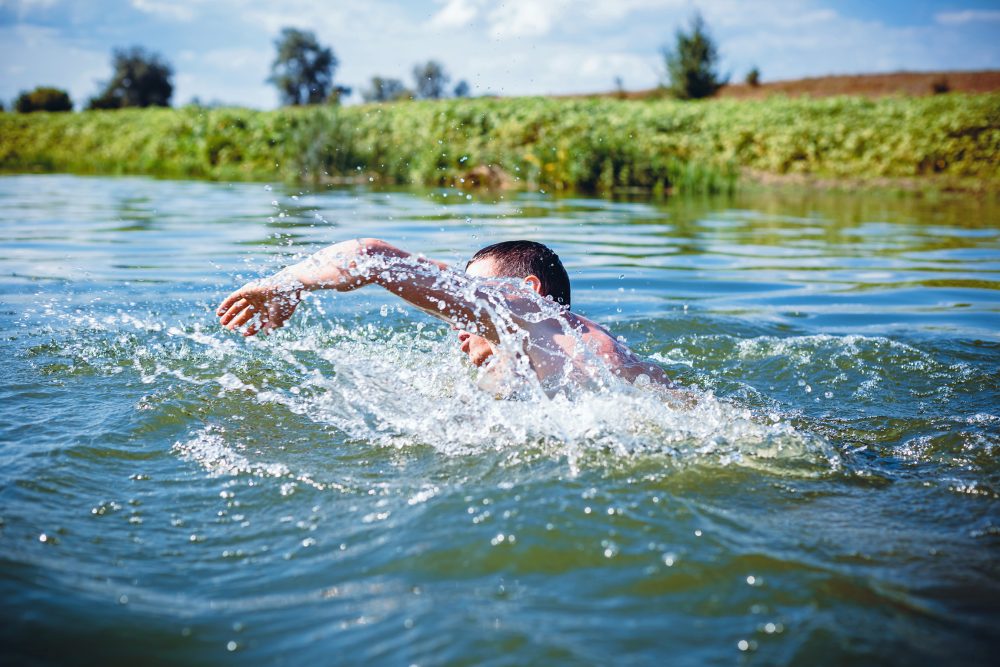 The,Young,Man,Swimming,In,The,River.