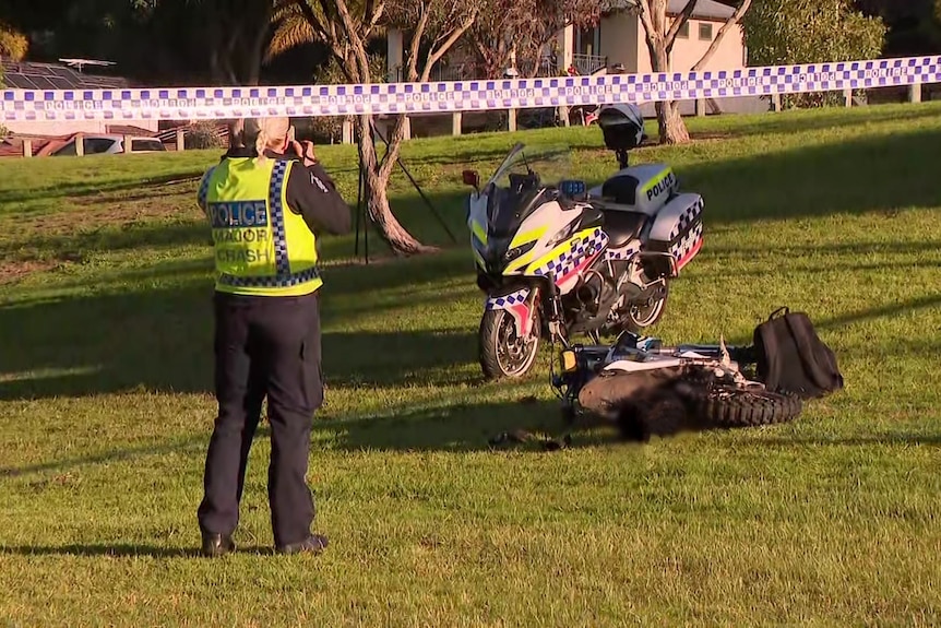 Police taking photos of the off road motorbike with a police motorcycle nearby