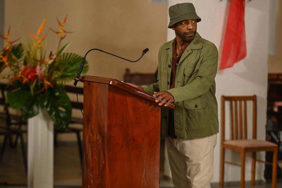 person at a podium with a microphone in a ceremonial setting