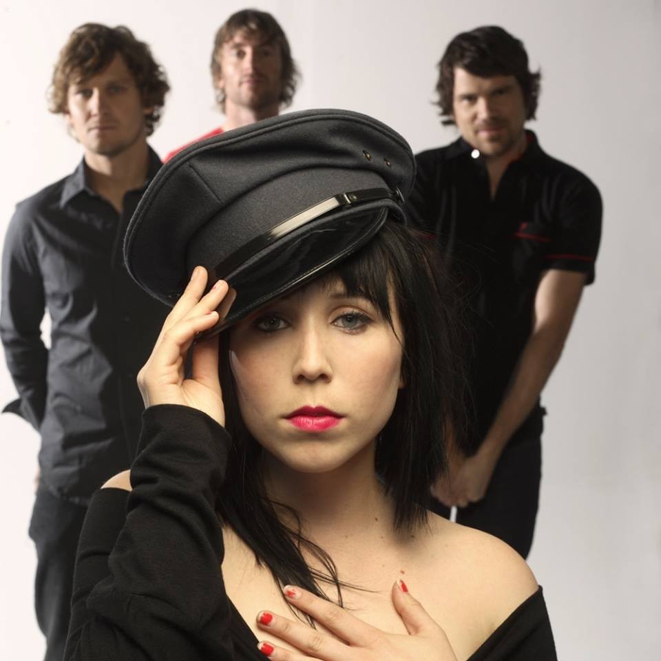 Group photo with person in front wearing a dark hat and others standing in the background.