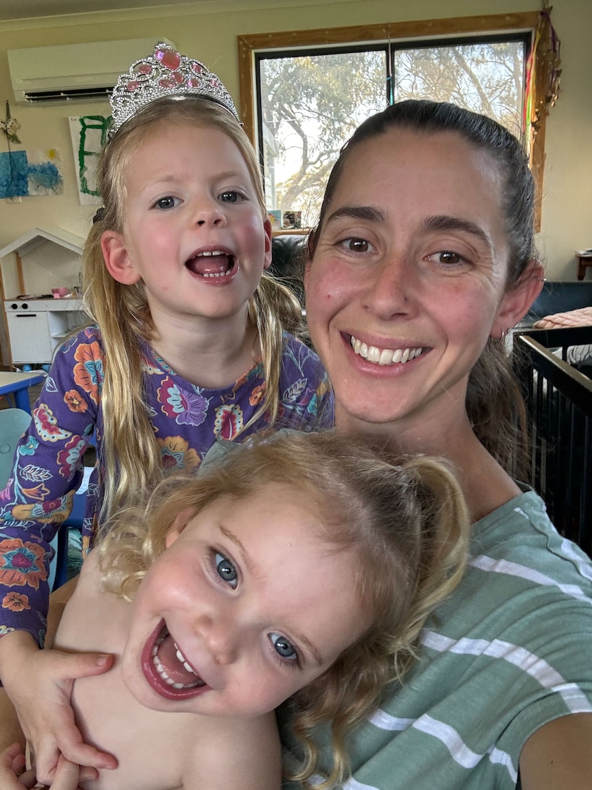 A woman and two girls smiling