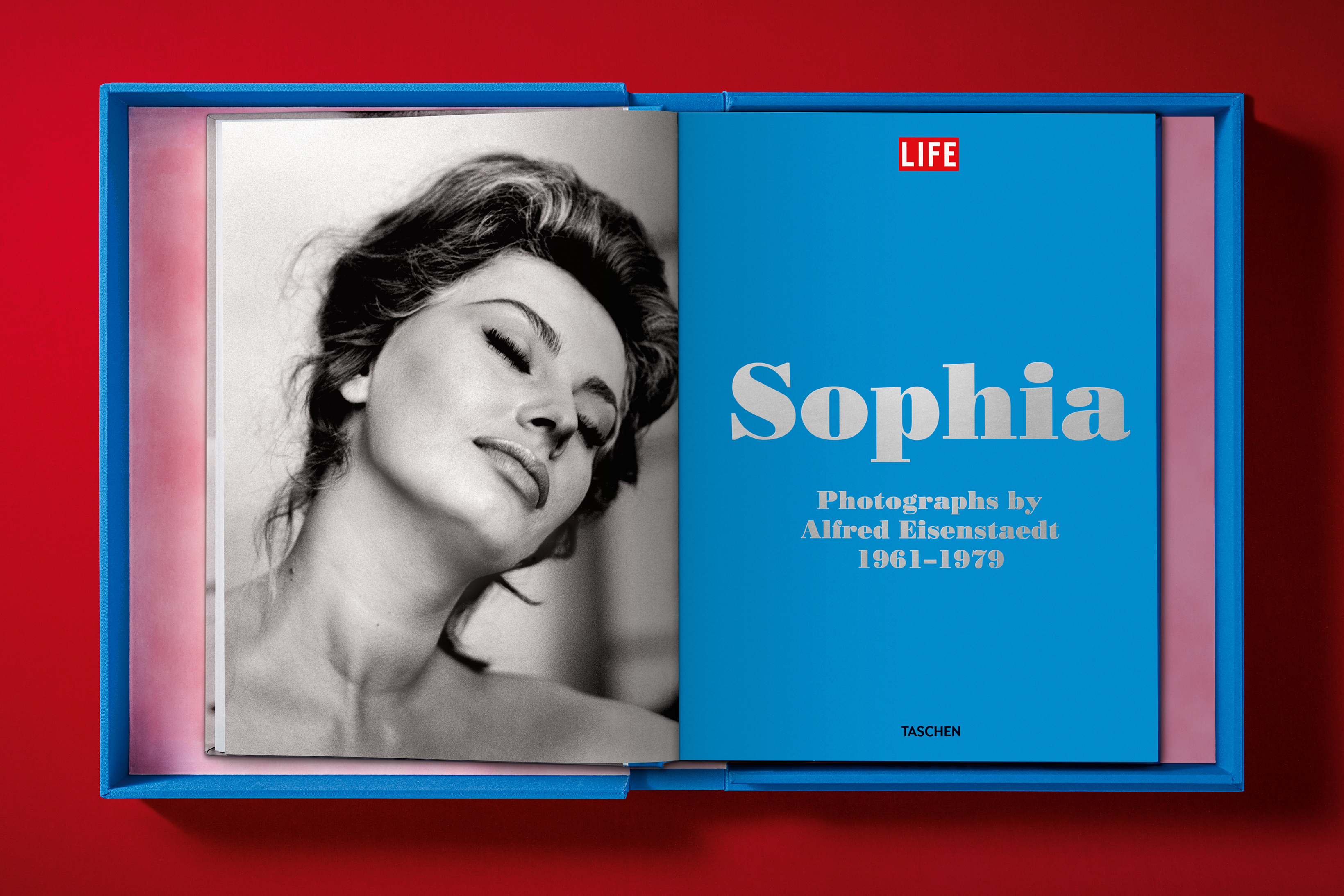 A bright blue collector's edition book box lies open on a red surface, revealing a black-and-white portrait of Sophia Loren with her eyes closed and a blue title page.